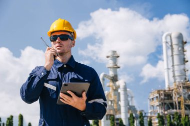 Rafineri petrol işçisi görev başında, telsiz kontrol operasyonu. Petrol ve gaz endüstrisi mühendisi petrokimya fabrikasında çalışıyor..