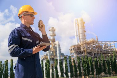 Rafineri petrol işçisi görev başında, telsiz kontrol operasyonu. Petrol ve gaz endüstrisi mühendisi petrokimya fabrikasında çalışıyor..