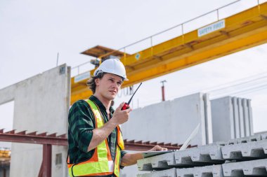 Beton precast fabrika kontrolünde çalışan profesyonel mühendis beyaz erkek inşaat alanında çalışıyor..