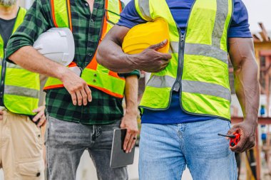 İnşaat endüstrisinde çalışan yakın plan işçiler. Çeşitli işçiler bir arada duruyor. Endüstriyel mühendisler takım konsepti.