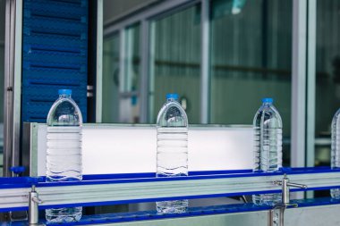 Hafif teftiş süreci, içme suyu üretim hattı. İçki fabrikasında plastik su şişeleri..