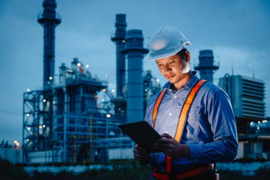 Gece vardiyası mühendisi, petrol rafinerisi, erkek işçi, petrol endüstrisinde sıkı çalışma karanlık arka plan..