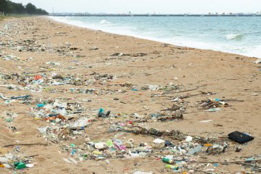 Çöpler sahilde yıkandı, kirli deniz çöpleri, plastik bardaklar ve plajda plastik torbalar. Çevresel okyanus ve kıyı sorunu.