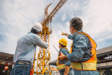 Profesyonel inşaat mühendisi ekibi birlikte çalışarak Crane Kulesi 'ni inşaat alanında kontrol ediyor..