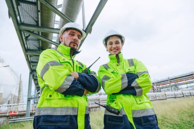 Portre yağı ve gaz rafinerisi mühendisi insanlar mutlu bir gülümsemeyle ayakta duruyorlar, petrol endüstrisinde birlikte akıllı uzman ekip çalışması yapıyorlar..