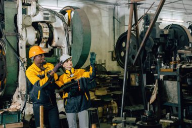 Profesyonel mühendis ekibi ağır endüstri atölyesindeki servis bakımını denetliyor.