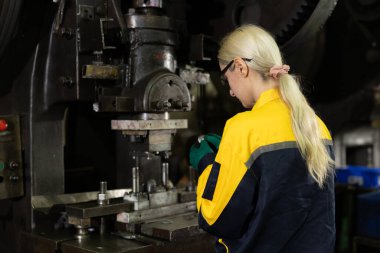 Kafkasyalı kadın işçi ağır metal endüstrisinde çalışıyor çelik makinelerini yumrukluyor.