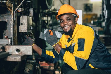 Portre profesyonel mühendisi siyah Afrikalı çelik atölyesi heavy metal fabrikasında mutlu makine bakım servisinde çalışıyor..