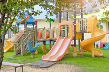 Oyun parkı renkli eğlence makinesi, küçük çocuklar okul bahçesi arka bahçedeki yeşil çimenler şehirde sergileniyor.