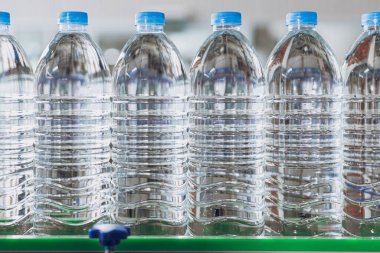 Taşıyıcı bantta su üretim hattı. PET Plastik Su Şişeleri içki fabrikasında. Evcil hayvan şişeleri endüstrisi.
