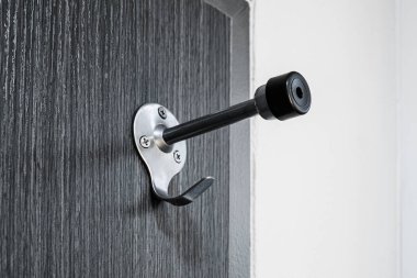 Kancalı kapı tutucu. Otel kapı freni koruma, elbise askısıyla duvara çarpmış.