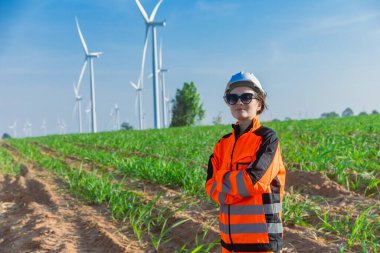 Portre Mühendisi genç kadın işçi. Tarım rüzgârı türbini çiftliğinde çevreye duyarlı kavramlar için çevre dostu yeşil enerji kesişiyor..