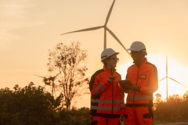 Profesyonel mühendis servis onarım... rüzgar türbini... yeşil enerji... temiz enerji... akşam üstü... turuncu arka plan...