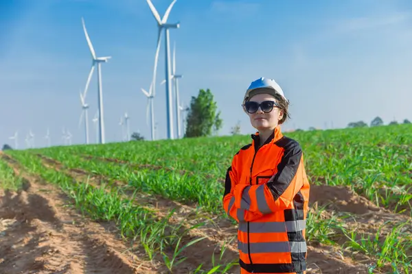 Portre Mühendisi genç kadın işçi. Tarım rüzgârı türbini çiftliğinde çevreye duyarlı kavramlar için çevre dostu yeşil enerji kesişiyor..