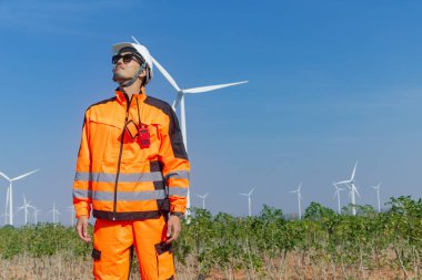 Profesyonel Asyalı mühendis teknisyen erkek işçi servis onarım rüzgar türbini temiz elektrik santralini kontrol ediyor. Rüzgar enerjisi jeneratörü çiftliği..