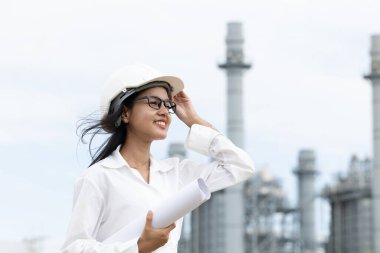 Profesyonel akıllı vizyonlu genç mühendis kadınlar rafineri elektrik santralinin kat planına karşı çıkıyorlar. Büyük endüstri inşaatı gelecek proje yönetimi kavramı.