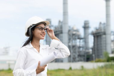 Profesyonel akıllı vizyonlu genç mühendis kadınlar rafineri elektrik santralinin kat planına karşı çıkıyorlar. Büyük endüstri inşaatı gelecek proje yönetimi kavramı.