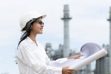 Profesyonel akıllı vizyonlu genç mühendis kadınlar rafineri elektrik santralinin kat planına karşı çıkıyorlar. Büyük endüstri inşaatı gelecek proje yönetimi kavramı.