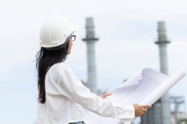 Profesyonel akıllı vizyonlu genç mühendis kadınlar rafineri elektrik santralinin kat planına karşı çıkıyorlar. Büyük endüstri inşaatı gelecek proje yönetimi kavramı.