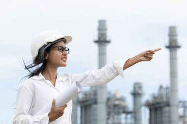 Profesyonel akıllı vizyonlu genç mühendis kadınlar rafineri elektrik santralinin kat planına karşı çıkıyorlar. Büyük endüstri inşaatı gelecek proje yönetimi kavramı.