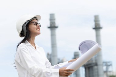 Profesyonel akıllı vizyonlu genç mühendis kadınlar rafineri elektrik santralinin kat planına karşı çıkıyorlar. Büyük endüstri inşaatı gelecek proje yönetimi kavramı.