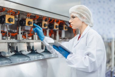 Endüstri müfettişi ekibi çalışıyor, QC personeli içki fabrikasında güvenlik ve hijyen için makine operasyonlarını kontrol ediyor.