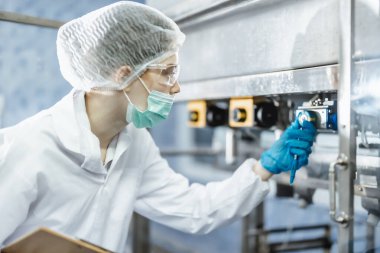 Endüstri müfettişi ekibi çalışıyor, QC personeli içki fabrikasında güvenlik ve hijyen için makine operasyonlarını kontrol ediyor.