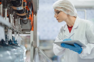 Endüstri müfettişi ekibi çalışıyor, QC personeli içki fabrikasında güvenlik ve hijyen için makine operasyonlarını kontrol ediyor.