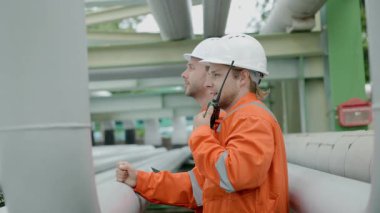 Petrol rafinerisi işçisi, petrol ve doğalgaz boruları ve valf müfettişi, petrol sızıntısı kontrol ediliyor.