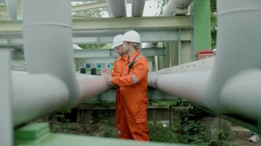 Petrol rafinerisi işçisi, petrol ve doğalgaz boruları ve valf müfettişi, petrol sızıntısı kontrol ediliyor.