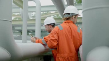 Petrol rafinerisi işçisi, petrol ve doğalgaz boruları ve valf müfettişi, petrol sızıntısı kontrol ediliyor.