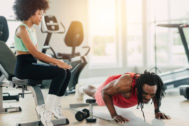 Afrikalı siyah sağlıklı baba ve neşeli afro kız çocuğu spor kulübü tatilinde birlikte eğleniyorlar, çocukların babası spor salonunda.