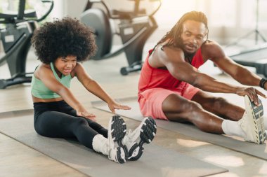 Spor Afrikalı Afrikalı zenci kız, spor antrenörüyle spor antrenmanı yapan genç atlet çocuk spor salonunda esneme hareketleri yapıyor.