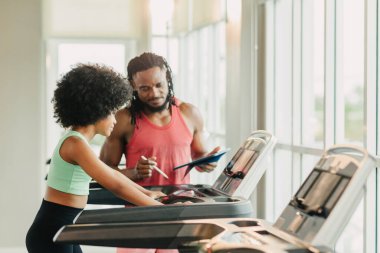 Spor Afrikalı zenci kız, spor antrenörü spor antrenörü ile spor antrenmanı yapan çocuk beden eğitimi kulübünde koşu bandında.