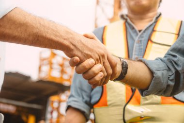 İnşaat alanında çalışan müteahhitlerle el sıkışma anlaşması. Mühendis projesi iş bağlantısı insanlar kavramı.