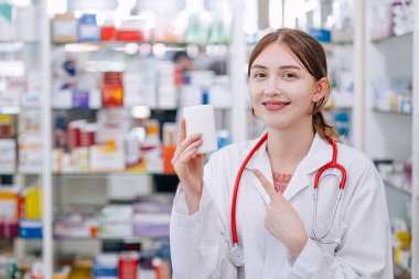 Eczanedeki Mutlu Doktor Eczacı elinde ilaç kutusunu göstererek gülümsemesini tavsiye ediyor.