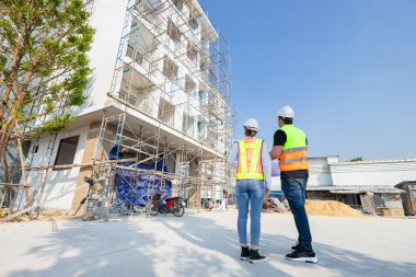 Backview İnşaat Mühendisi, inşaat alanında birlikte çalışan mimar. İnşaat işçisi inşaat alanında plan yapıyor.