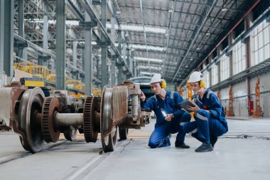Tren lokomotifi mühendisi tren istasyonundaki bakım demiryolu raylarını teftiş ediyor mühendislik taşımacılığı endüstrisini ilerletiyor.
