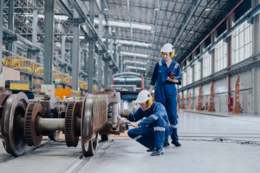 Tren lokomotifi mühendisi tren istasyonundaki bakım demiryolu raylarını teftiş ediyor mühendislik taşımacılığı endüstrisini ilerletiyor.