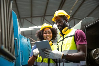 Afrikalı siyahi adam profesyonel teknisyen mühendis ağır endüstri eğitim kontrolündeki işçiler CNC makinesini genç kadınlara çalıştırıyor