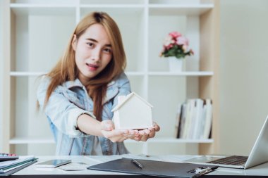 Emlakçı müşterilere yeni ev anahtarı veriyor. İpotek sözleşmeleri, krediler, ev satın alma sözleşmeleri ve ev satışları. Emlak kredisi işi