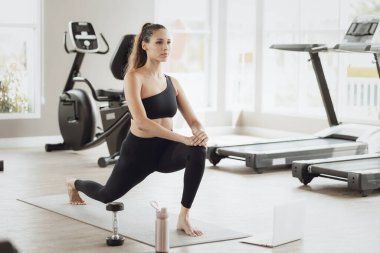 Çevrimiçi Sağlık Eğitimi. Genç Fit Kadın Spor Kulübü 'nde egzersiz yapıyor, Dizüstü bilgisayarda video dersi izliyor.