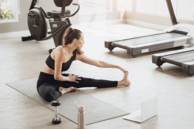 Çevrimiçi Sağlık Eğitimi. Genç Fit Kadın Spor Kulübü 'nde egzersiz yapıyor, Dizüstü bilgisayarda video dersi izliyor.