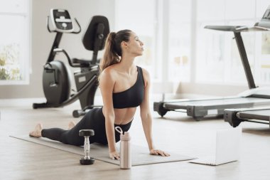 Çevrimiçi Sağlık Eğitimi. Genç Fit Kadın Spor Kulübü 'nde egzersiz yapıyor, Dizüstü bilgisayarda video dersi izliyor.