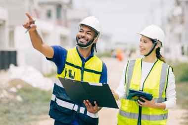 İnşaat mühendisi, mühendis ekip çalışanı ve kadınlar inşaat alanında ev yapımı projeleriyle birlikte çalışıyorlar.