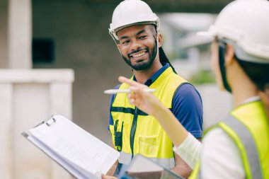 Mutlu İnşaat Mühendisi gülümsüyor, ustabaşı projeden memnun. Mutluluk gülümsemesi.
