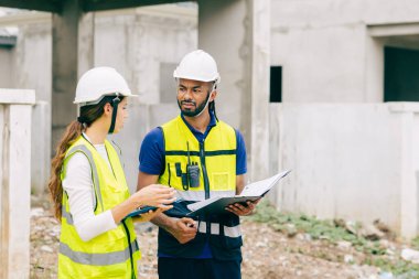 İnşaat mühendisi, mühendis ekip çalışanı ve kadınlar inşaat alanında ev yapımı projeleriyle birlikte çalışıyorlar.