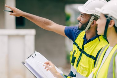Mutlu İnşaat Mühendisi gülümsüyor, ustabaşı projeden memnun. Mutluluk gülümsemesi.