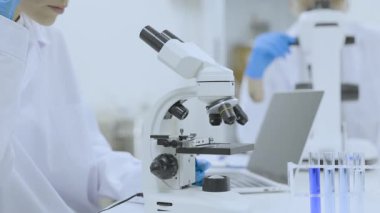 Fen laboratuvarında çalışan yakın plan bilim kadını doktor kadınlar, farmasötik laboratuarında araştırma yapan tıbbi araştırma ekibi, ileri teknoloji ekipmanları ve mikroskop ile