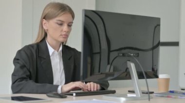 İş kadını Masaüstü Bilgisayarı kullanırken Kameraya Bakıyor